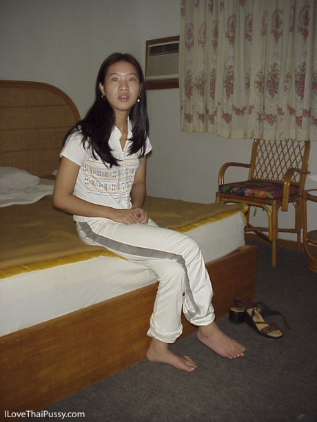 Sleazy chinese babe taking off her clothes and posing on the bed