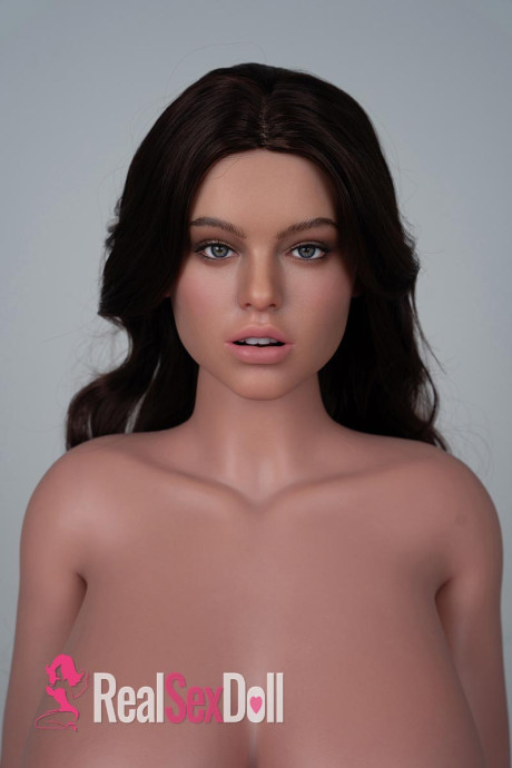 Sex doll with an incredible figure poses naked in front of windows