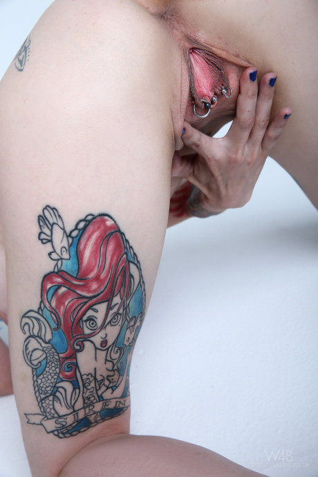 Teen with blue hair exposes her slender body, large tits and hot tattoos