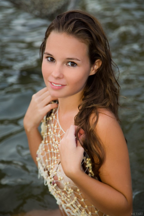 Glamorous teenie Aria A	displays her hot body with tan lines on the beach