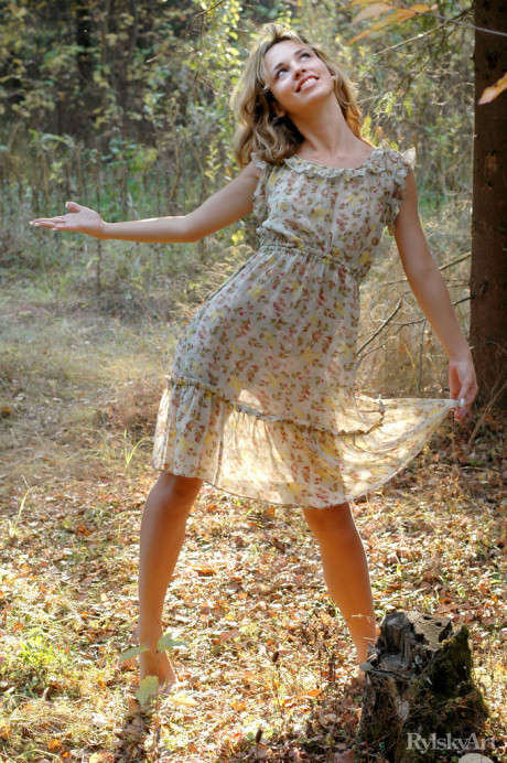 Young young blondy Natalia B takes off her dress to go totally nude in the woods