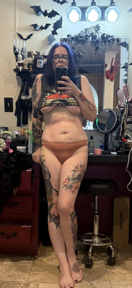 Tattooed amateur with purple hair and glasses takes selfies in the nude