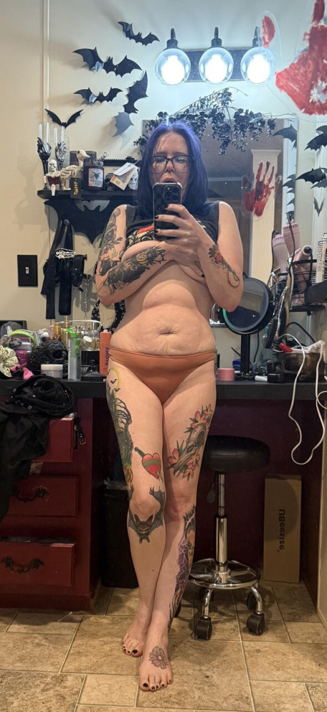 Tattooed amateur with purple hair and glasses takes selfies in the nude