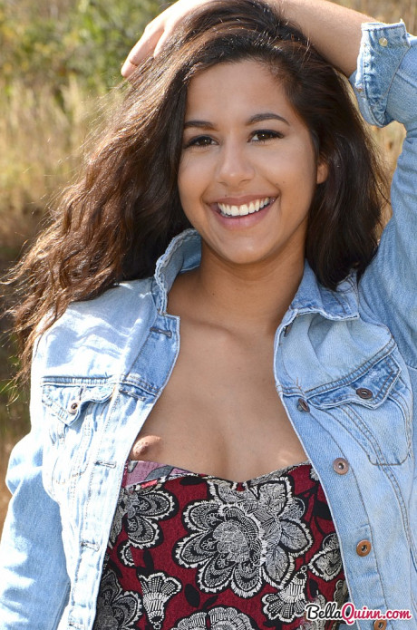Latina first timer Bella Quinn covers up her exposed breasts in a field