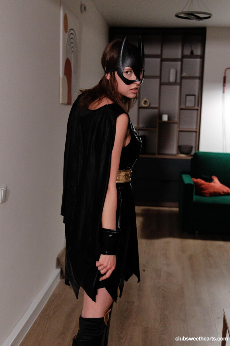 Sweet brunette takes off a Batman costume to model naked in a mask