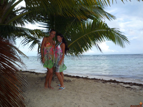 Beautiful girls work free of their swimwear while modeling on a tropical beach