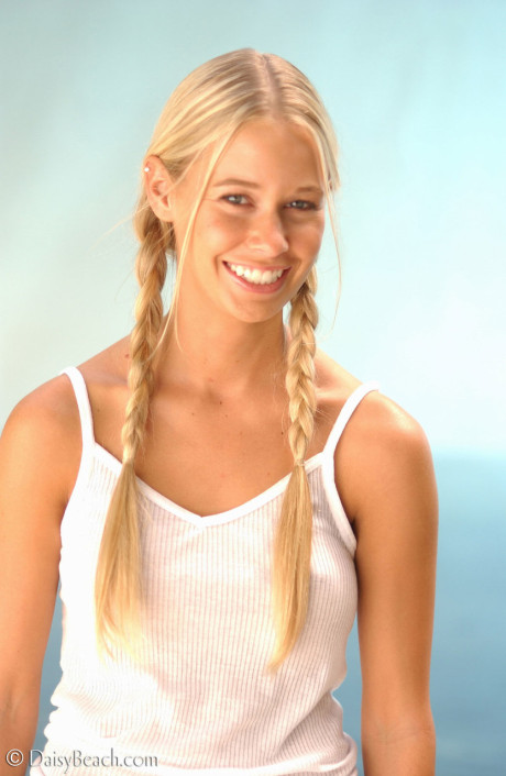 Stunning blondy Sarah places a hand over her large boobs at the beach