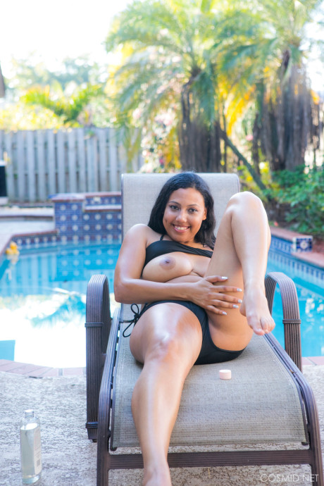 Chubby ebony amateur removes her bikini to pose undressed on chair by a pool