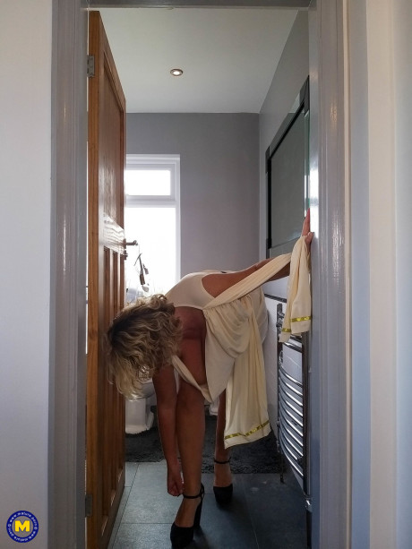 Blonde cougar with huge boobs Camilla C shows her bum in a solo
