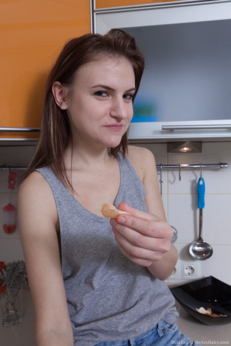 Lovely amateur Mila Lee unveils her small tits and bushy snatch in the cuisine