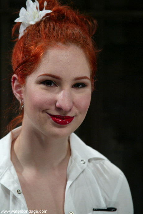 Pale ginger head is silenced and restrained with rope in a dungeon