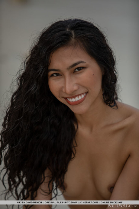 Hot brunette teen Niki does away with her bikini to go nude on a beach