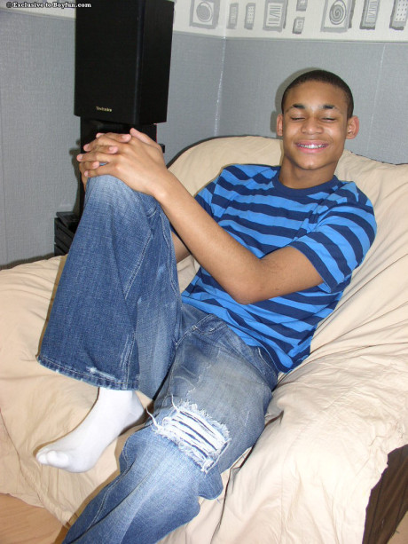 Attractive black gay Andrew smiles while stripping and masturbating in a solo