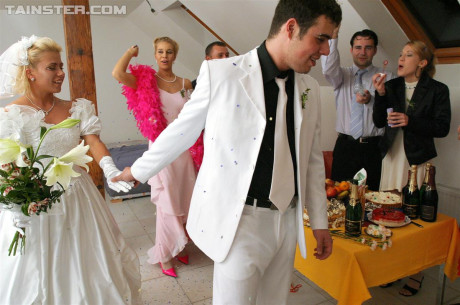 New bride dressed in her wedding dress plays water sport games at reception