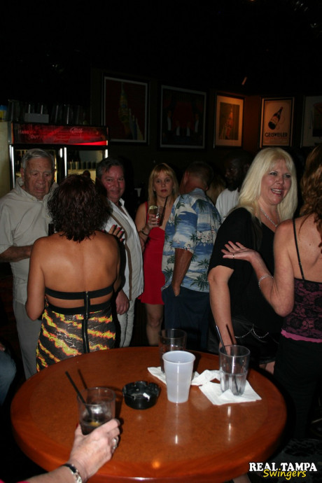Insatiable swinger wives show off their giant tits and lick hard cocks in public