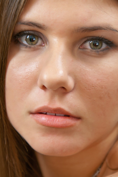 Charming young Kira K bares her tiny boobies and lovely pussy on the sofa
