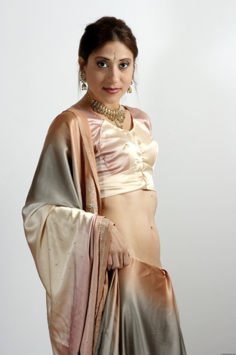 Indian female uncovers her tiny breasts as she removes traditional clothing