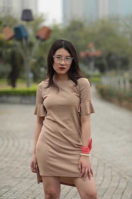 Thin oriental babe with eyeglasses posing in her tight skirt in public