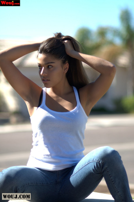 Tanned amateur babe posing in her white shirt and blue jeans in public
