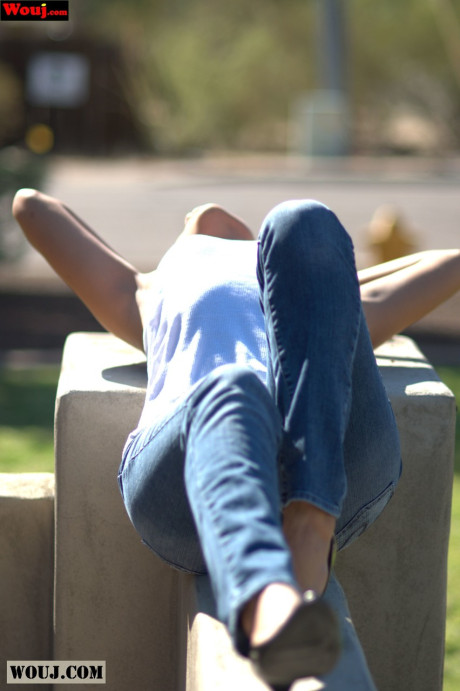 Tanned amateur babe posing in her white shirt and blue jeans in public