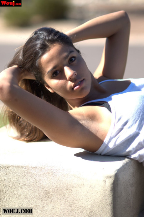 Tanned amateur babe posing in her white shirt and blue jeans in public