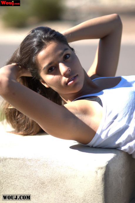 Tanned amateur babe posing in her white shirt and blue jeans in public