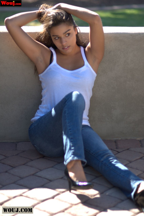 Tanned amateur babe posing in her white shirt and blue jeans in public