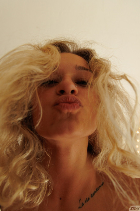 Sexy blonde Jezebel Madd turns to show her bareback butt while undressed
