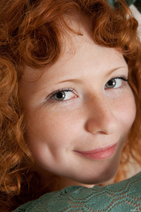 Curly-haired red hair Rochelle exposes her charming body and poses on her bed