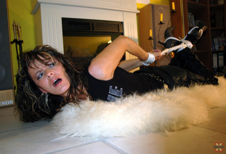 Clothed Caucasian female Jenna struggles on a rug while hogtied