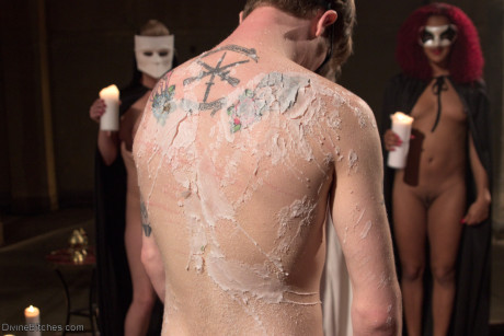 Horny dommes drip hot wax on a bound man back in a secret BDSM sex ritual