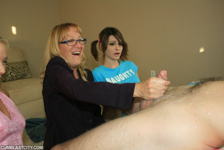 Older yellow-haired in glasses teaching her teenie friends how to stroke a humongous rod