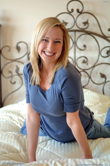 Glamour babe with a ravishing smile Kaitlyn toys her shaved twat on her bed