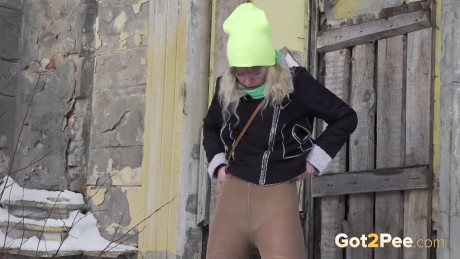 Fine blonde squats in the snow to relieve herself