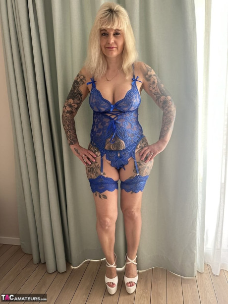 Tattooed blondie Inked MILF uncovers her giant boobs while removing her underwear