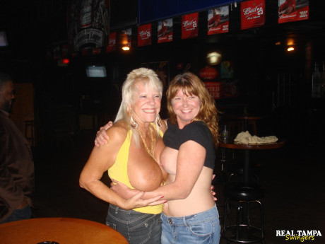 Yellow-haired amateur cougar shows her shaved clam in the swinger night club