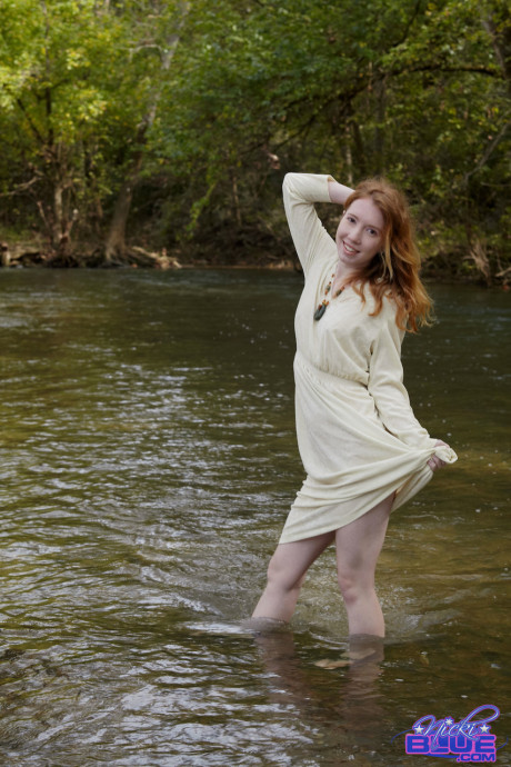 Redheaded American pornstar Nicki Blue reveals her sexy behind in the river