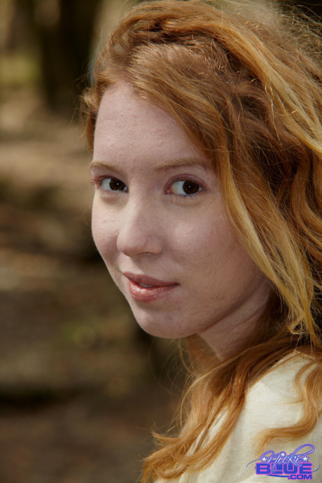 Redheaded American pornstar Nicki Blue reveals her sexy behind in the river