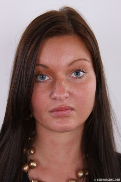Brunette amateur Aneta stands clothed in boots before her first nudes
