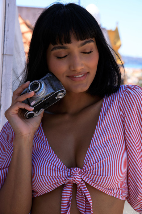 Dark haired beauty Angel Constance unveils her tits and poses on the terrace