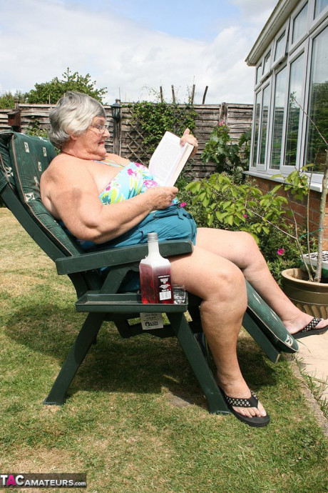Slutty amateur old lady Libby inserting a bottle in her chunky cunt in the garden