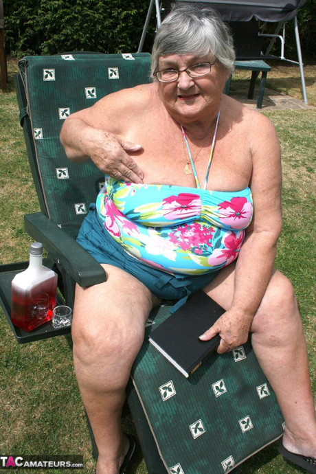 Slutty amateur old lady Libby inserting a bottle in her chunky cunt in the garden