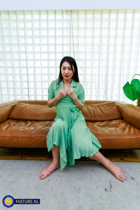 Japanese MILF Megumi Satuki shows her body and poses on a couch