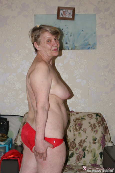 Yellow-haired old lady Belly loses her red undies & shows her saggy melons & furry pussy