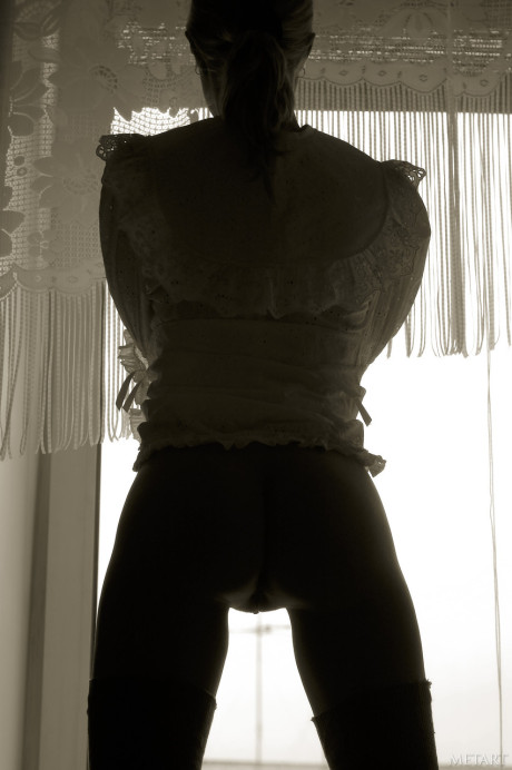 Pantyless babe shows her puffy nipples and twat while posing by the window