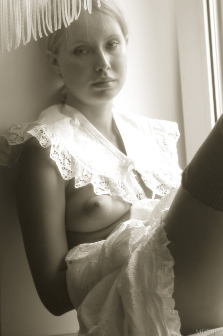 Pantyless babe shows her puffy nipples and twat while posing by the window