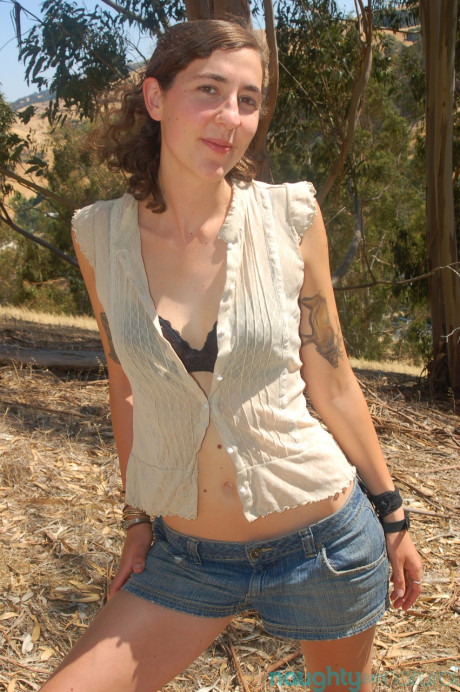 Brunette amateur Artemis shows her tiny titties and rubs her bush outdoors