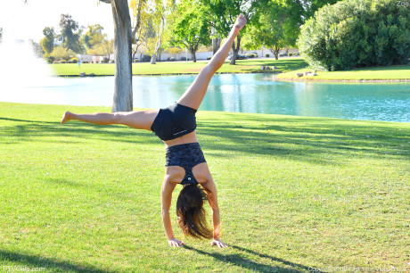 Teenage beauty in charming outfit Zoe doing exercise outdoors by the water