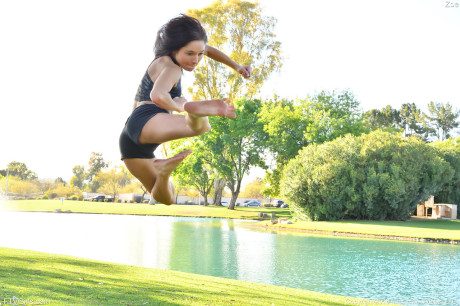Teenage beauty in charming outfit Zoe doing exercise outdoors by the water