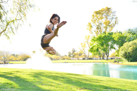 Teenage beauty in charming outfit Zoe doing exercise outdoors by the water